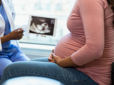 Midwife monitoring fetal heartbeat during prenatal visit at PMBcare