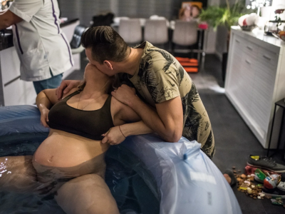 Mother in water birth pool with PMBcare midwife at Lenasia clinic, Johannesburg